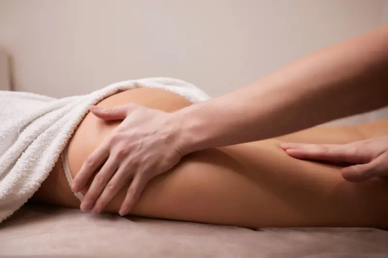 Massage drainant de la cuisse et de la hanche, drap de bain sur la patiente