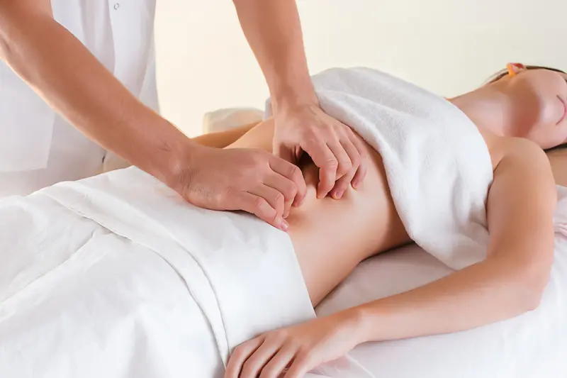 Séance de drainage lymphatique sur table de massage, patiente allongée et couverte